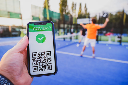 Man showing vaccination certificate covid-19 with app on smartphone first to do sport, coronavirus conceptの写真素材