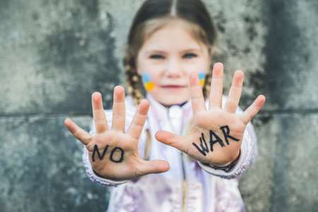Beautiful and scared child inscription NO WAR on his hands. Russia's invasion of Ukraine, kids against the warの写真素材