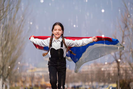 Happy Ukrainian girl running at the park waving the yellow and blue national flag. Concept of love for Ukraine. Independence, flag, Constitution Day of Ukraineの写真素材