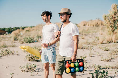 Group of laughing young friends in summer clothes going for a picnic at the beachの写真素材