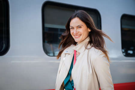 Portrait of a business woman commuter walking in a train station or airport going to boarding gate with hand luggageの写真素材