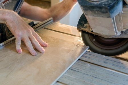 A wet saw cutter is being used to cut floor tile