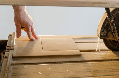 A wet saw cutter is being used to cut floor tileの写真素材