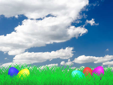Easter Eggs lying on a meadow with the sky and clouds in the backgroundの写真素材
