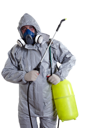 A pest control worker wearing a mask, hood, protective suit and dual air filters holding a hose to help exterminate rats and other vermin.の写真素材