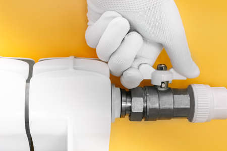 A locksmiths hand in a white glove covers the radiator in the house. The concept of energy...
