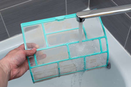 Washing the filter from the internal unit of the split system under water pressureの写真素材