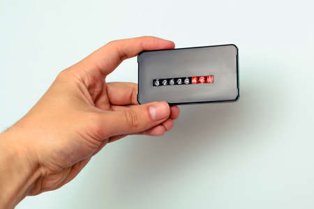 A man holds an electricity meter in his hand. The concept of increased electricity pricesの写真素材