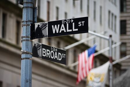 Wall Street sign with American flag in the Financial District of Lower Manhattan