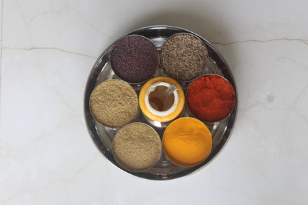 Various spices in a metal bowl on white marble background. Top view. Authentic Indian Spices are used in all the kitchens in India.の写真素材