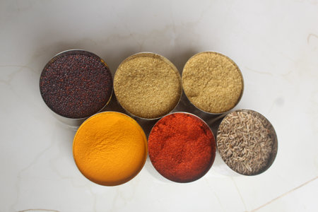 Colorful spices in bowls on white marble background. Top view. Authentic Indian Spices are used in all the kitchens in India.の写真素材