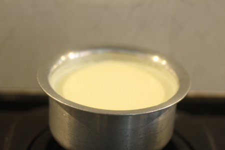 Cheese fondue in a stainless steel pot on a gas stoveの写真素材