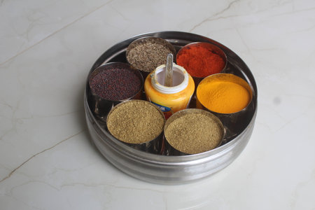 Colorful spices in a metal container on a white marble background. Authentic Indian Spices are used in all the kitchens in India.の写真素材