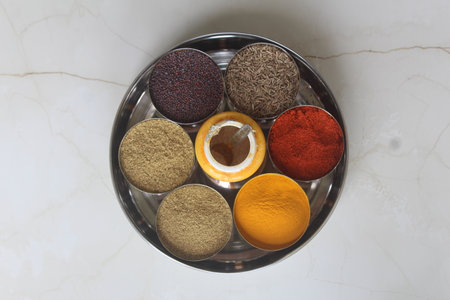 Various spices in a metal bowl on a marble background. Top view. Authentic Indian Spices are used in all the kitchens in India.の写真素材
