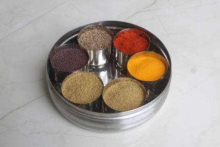 Colorful spices in metal container on white marble background. Top view. Authentic Indian Spices are used in all the kitchens in India.の写真素材