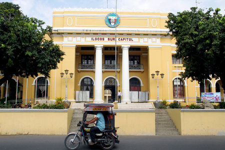 a a traysikel (Filipino Motorized tricycle) passing by Ilocos Sur Capitol building in historical city of Vigan, Philippines.のeditorial素材