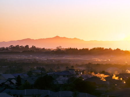 Morning sunrise beautiful winter golden light and fog over the suburbs of Rototuna and Flagstaff in the city of Hamilton New Zealand with Mount Te Aroha in the backgroundの写真素材