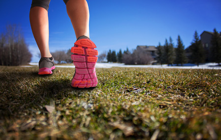 woman legs hiking hill with thawing snow on a sunny afternoon with a drama filter shallow depth of fieldの写真素材