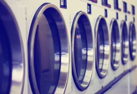laundromat machine washer line with closed doors shallow depth of fieldの写真素材