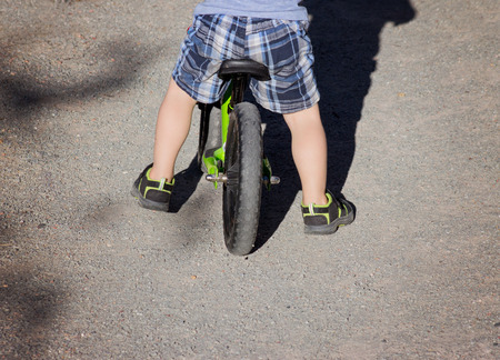abstract view of toddler riding bike on gravel path with retro instagram filter shallow depth of fieldの写真素材