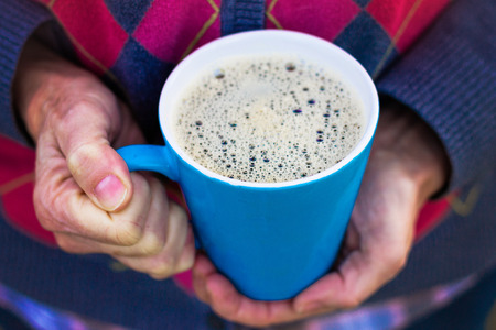 woman holding her cup of joe in the morning with a retro instagram filter shallow depth of fieldの写真素材