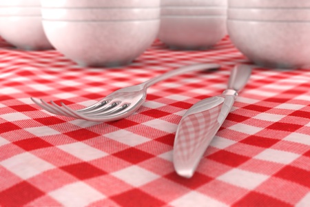 fork and knife closeup on a red table cloth with dashware behindの写真素材