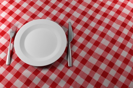 Fork Knife and Plate isolated on a red table clothの写真素材