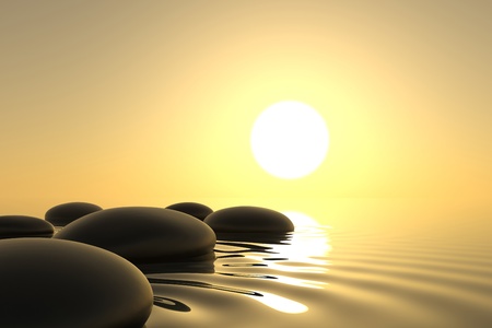 Zen stones into the water with sunset on backgroundの写真素材