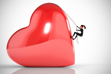 Woman thief climbs a big heart on a white backgroundの写真素材