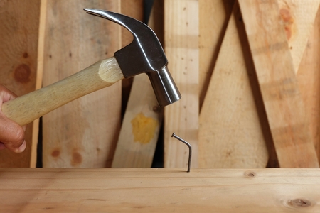 hammer hit the Nail bend on woodの写真素材
