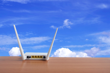 Modem router wifi wireless on wooden floor with blue sky and Clouds backgroundの写真素材