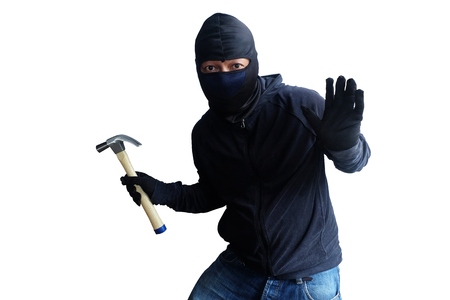 Masked thief with hammer isolated on white backgroundの写真素材