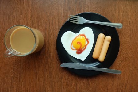 Breakfast, Fried egg with sausage and Coffee By the window balcony in the cold. Winter or raining, topview.の写真素材