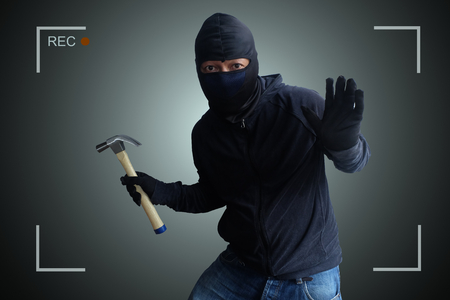 Camera capture and record caught Masked thief with hammer at night.の写真素材
