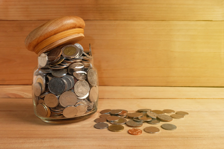 Saving money Coins In a glass bottle on wooden floorの写真素材