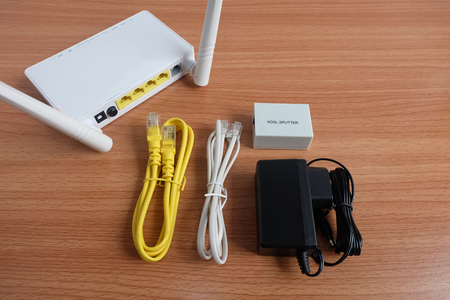 Complete set Modem router wifi wireless, lan and adsl cable, splitter, and Adapter on wooden floorの写真素材