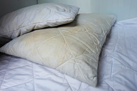 Dirty pillows on white beds are a source of germs and dust mites and mattressesの写真素材