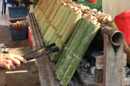 making "Khao Lam" Traditional Thai desserts, glutinous rice with coconut milk and baked in a length of bamboo cylinderの写真素材