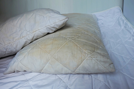 Dirty pillows on white beds are a source of germs and dust mites and mattressesの写真素材