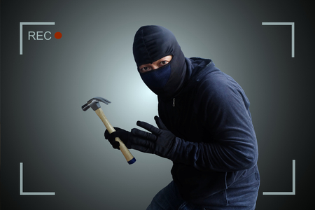 Camera capture and record caught Masked thief with hammer at night.の写真素材