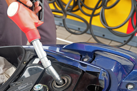 Oil dispenser are refilling the motorcycle.の写真素材