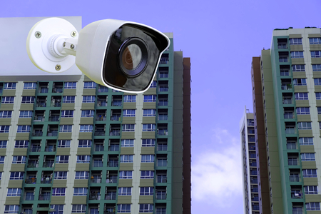 Closeup CCTV Camera of security at blurred Building tower with blue skyの写真素材