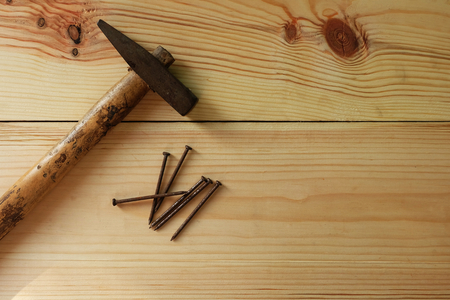 Old Hammer and nail on texture wooden background with Warm lightの写真素材