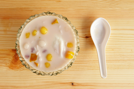 Colorful thai dessert "bua loy or bua Loi" Contains coconut milk, glutinous rice powder with poached egg, on wooden floorの写真素材