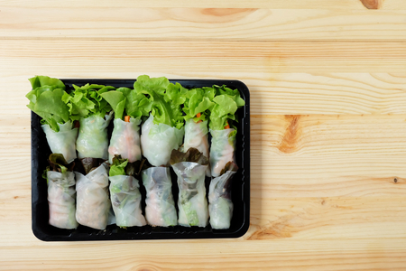 Roll salad Green oak and red oak fresh vegetables in a black plastic box on a wooden floor.Top view, with copy spaceの写真素材