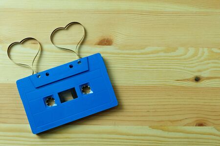 Blue cassette tape audio with label tape ribbon heart shape on wooden floors with Copy space, Valentine day The lovers are together concept.の写真素材