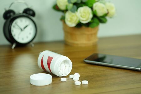 White pills and medicine bottles, paracetamol on desk wooden table, Headache medicine Vitamin And Dietary Supplements Concept.の写真素材