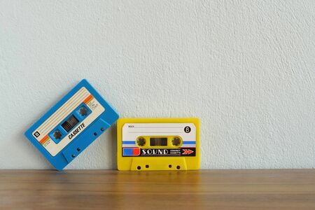 Old colorful cassette tape on wooden floor and leave blank space above for text inputの写真素材