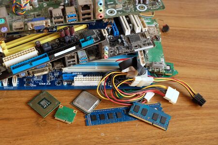 Pile of Motherboard computer, electronic equipment, Printed Circuit Board and orther broken or damage on wooden floor, Electronic waste problems, Environmental pollutionの写真素材