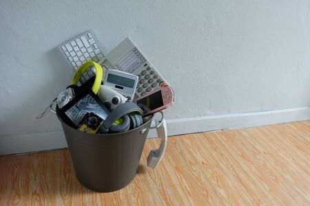 Electronic Waste broken or damage In Recycle bin in the room with white wall and leave blank space above for text input, Reuse and Recycle concept.の写真素材
